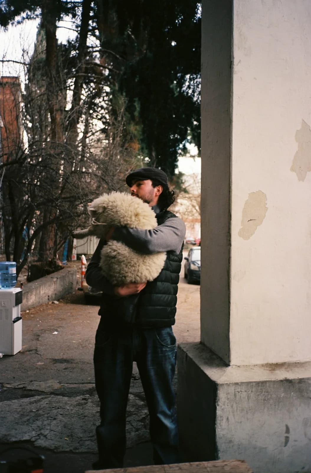 Holy Smear on location: a man carrying a sheep past a hospital column