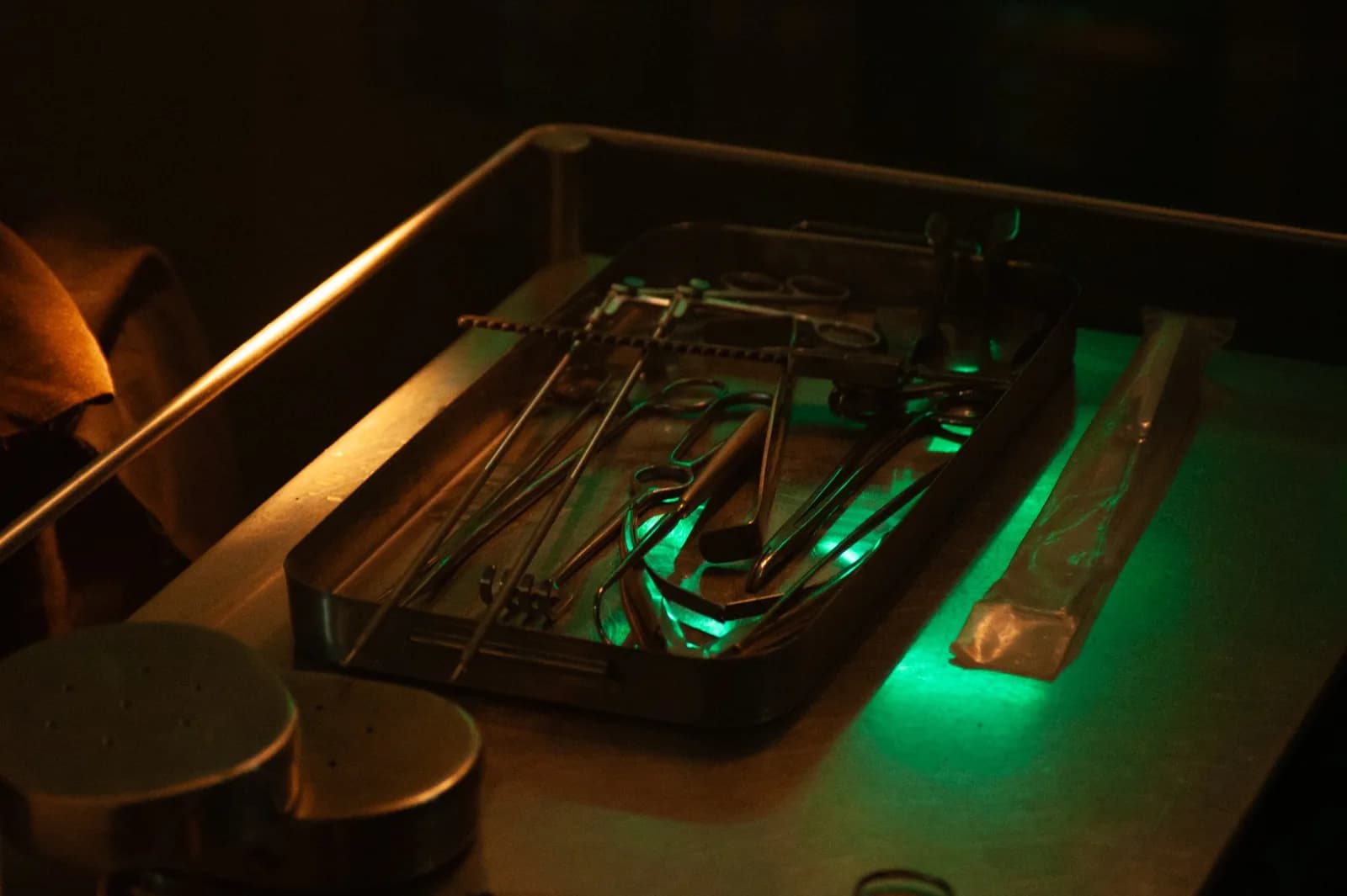 Holy Smear still: surgical instruments on a tray under green light