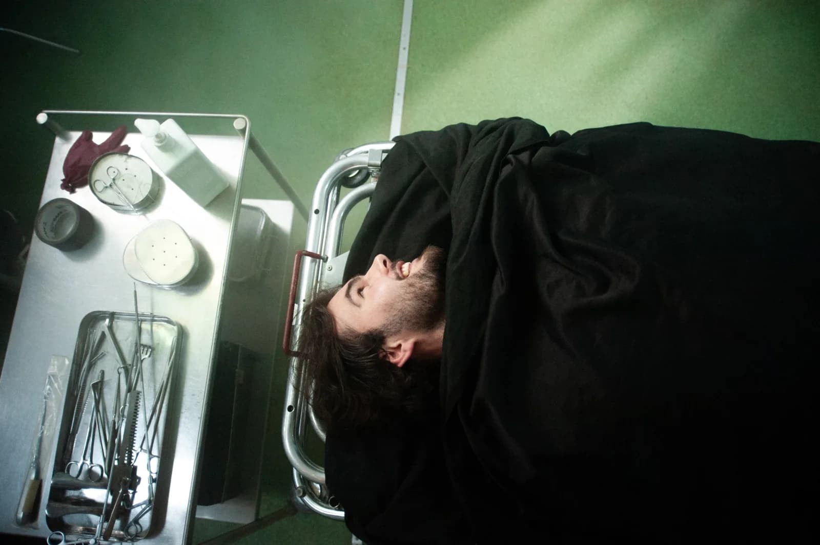 Holy Smear still: a patient on a gurney beside a tray of surgical instruments